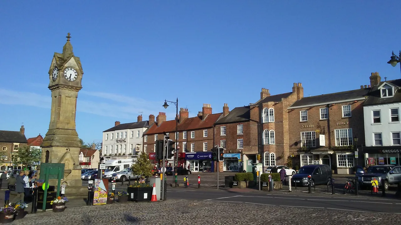 The stone clock tower in Thirsk Market Place, with the town’s shops beyond